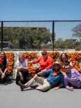 Registrar staff sitting in front of Pitzer flower sign