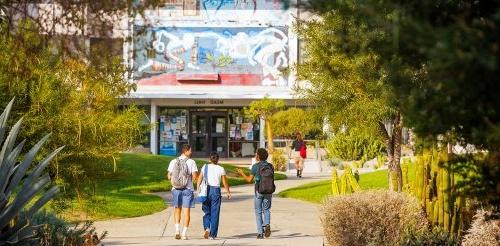 three students walk towards mead hall