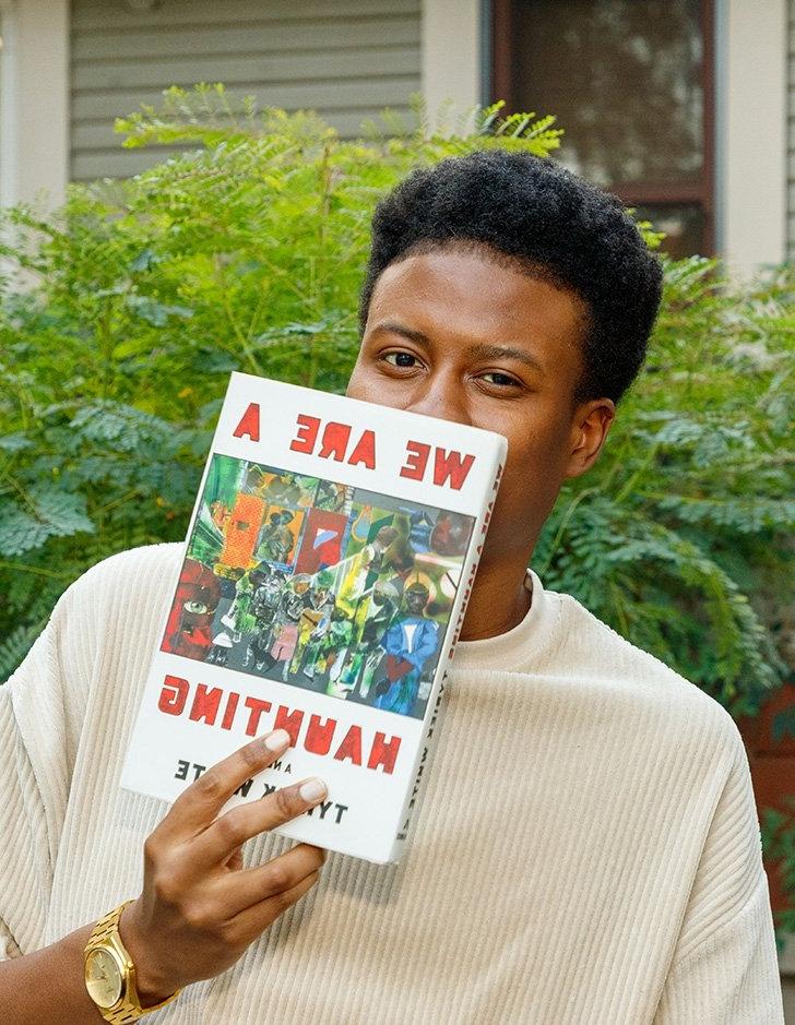 tyriek white holds up his novel "we are a haunting"