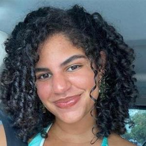 Headshot of Ana Hernandez, who has medium-length curly black hair.